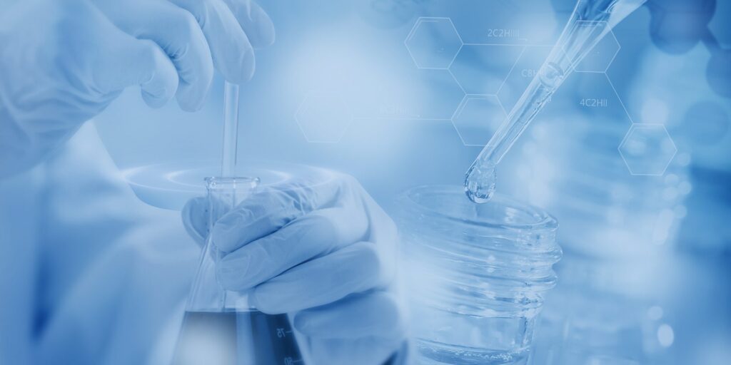 Laboratory glassware and gloved hands illustrating controlled material testing